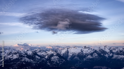 Aerial View from Airplane of Canadian Mountain Landscape with dark cloud abover. Colorful Sunset. Taken near Squamish, North of Vancouver, British Columbia, Canada. Authentic Image