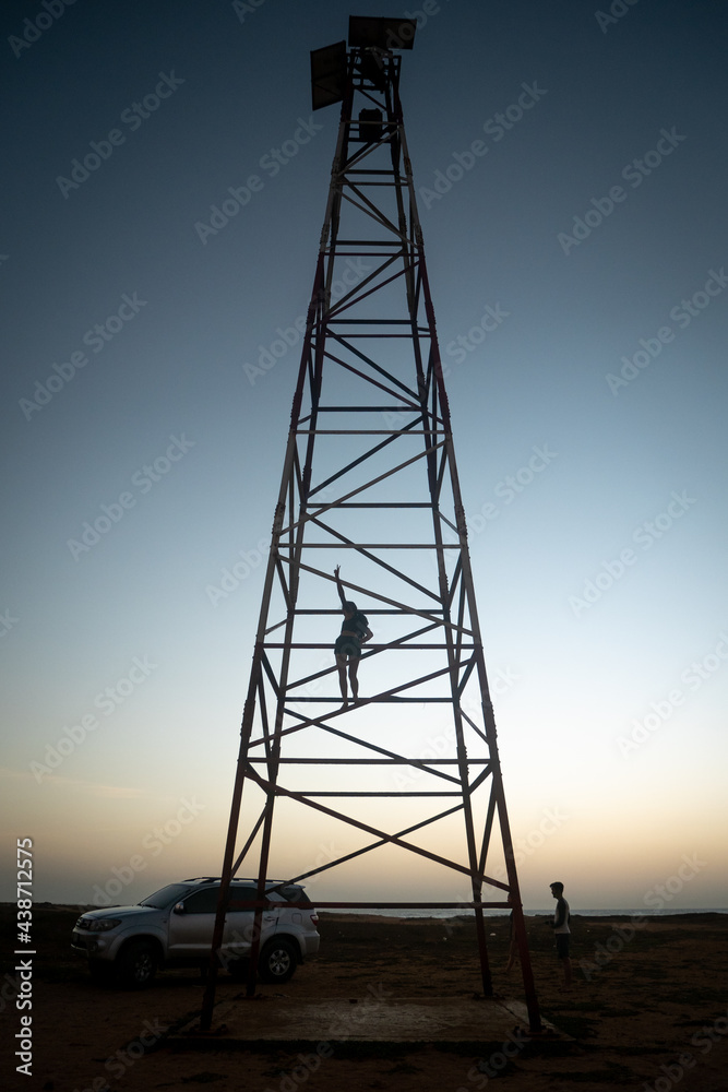 Young Woman is Climbing the Metal Tower at the Top of the Lighthouse at Punta Gallinas (Cape Gallinas, 