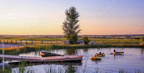 Kids floating on a lake with a dock during adventures on a ranch in Alta, Wyoming, on the west side of the Teton Mountains.  photo