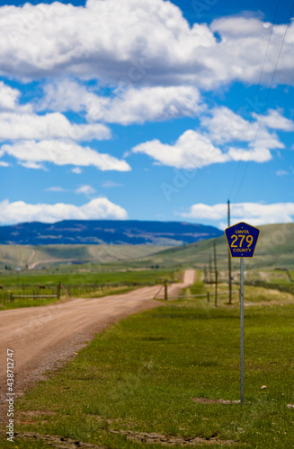 Photography A dirt road called Uinta county road 279 with a cattle guard ahead in Robertson, Wyoming and the ranches in the Bridger Valley