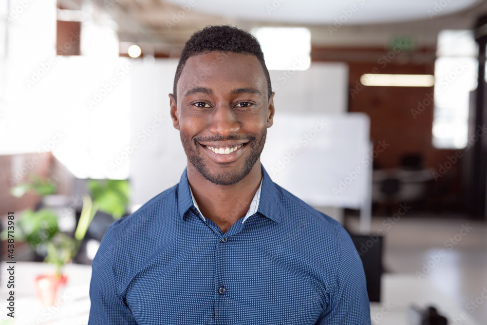 Fototapeta premium Portrait of african american businessman standing in office smiling to camera