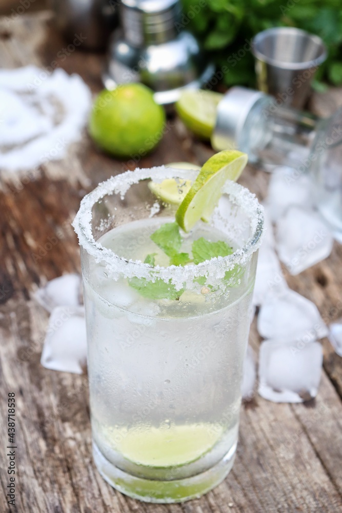 Making a margarita cocktail lime salt and mint leaves