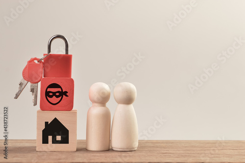 фотографія Wooden doll figures with padlock, scammer and home