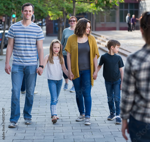 parent with kids walking in the park in good weather