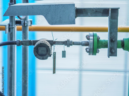Temperature transmitter for measuring instrument close up in industry zone at power plant.