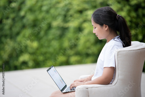 young woman using laptop in garden,work from home concept