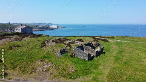 Abandoned Amlwch coastal countryside mountain house aerial slow low rising view overlooking Anglesey harbour photo