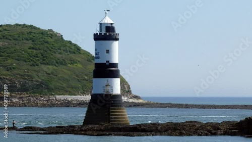 Sunny Penmon lighthouse Trwyn Du sightseeing motorboat sailing towards Anglesey landmark tower photo