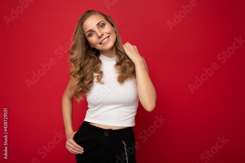 Photo portrait of young sexy beautiful attractive positive smiling blonde woman wearing white top isolated over red background with copy space