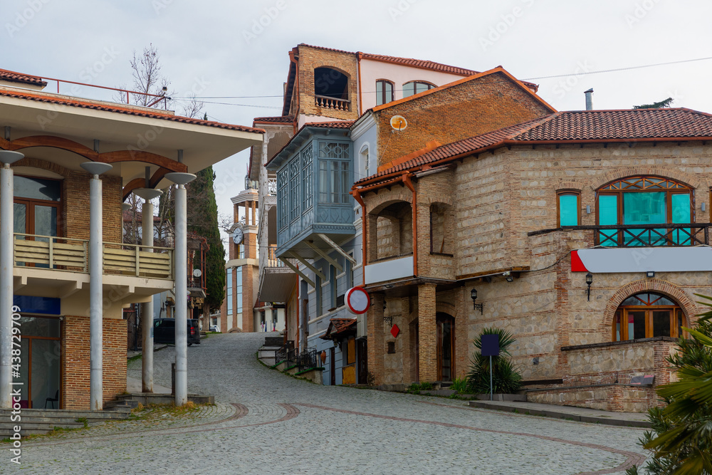Traditional old houses with carved balconies on narrow winding streets in small Georgian town of Sighnaghi in springtime