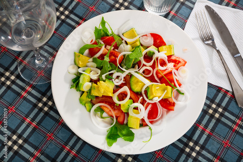 Fresh vegetable salad with avocado, tomato and onion in a restaurant
