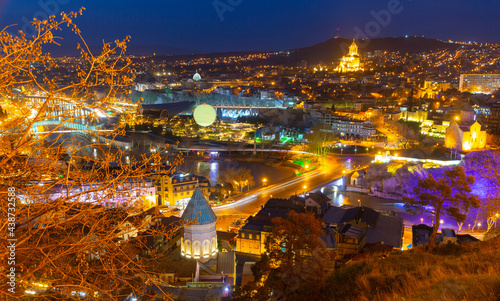 Scenic cityscape of town Tbilisi with illuminated buildings and bridges over Kura river  Georgia