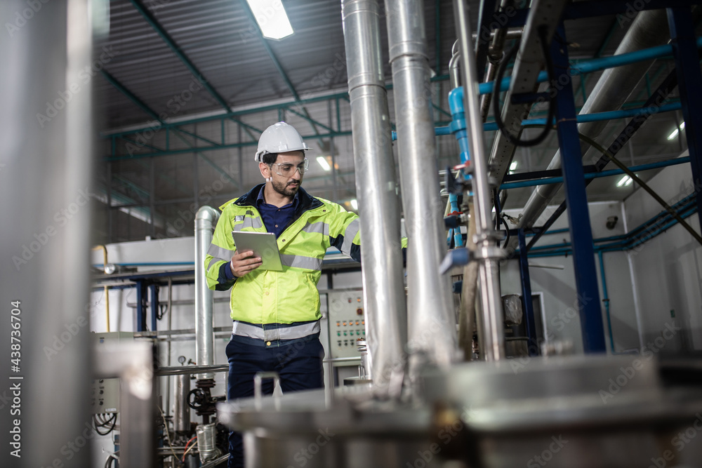 custom made wallpaper toronto digitalEngineer in uniform holding a tablet in her hands and conducting an inspection at the machine in Factory. Industrial production concept