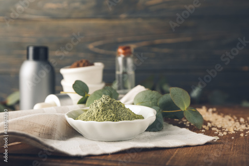 Foto Dry henna powder in bowl on wooden background, closeup