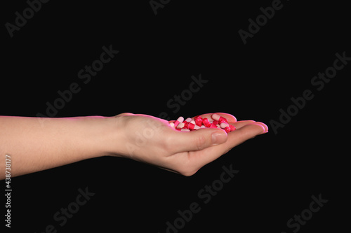 Hand with pills on dark bac...