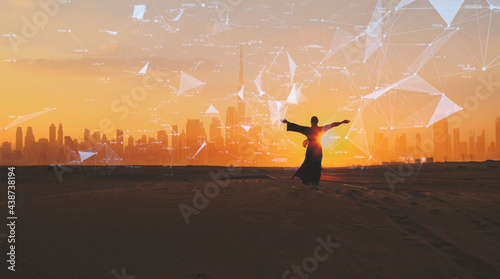 Woman rised her arms on the Dubai city background with on sunset. City connected to 5G technology photo