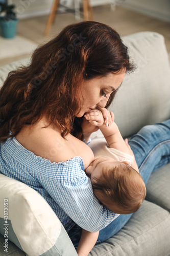 Young woman breastfeeding h...