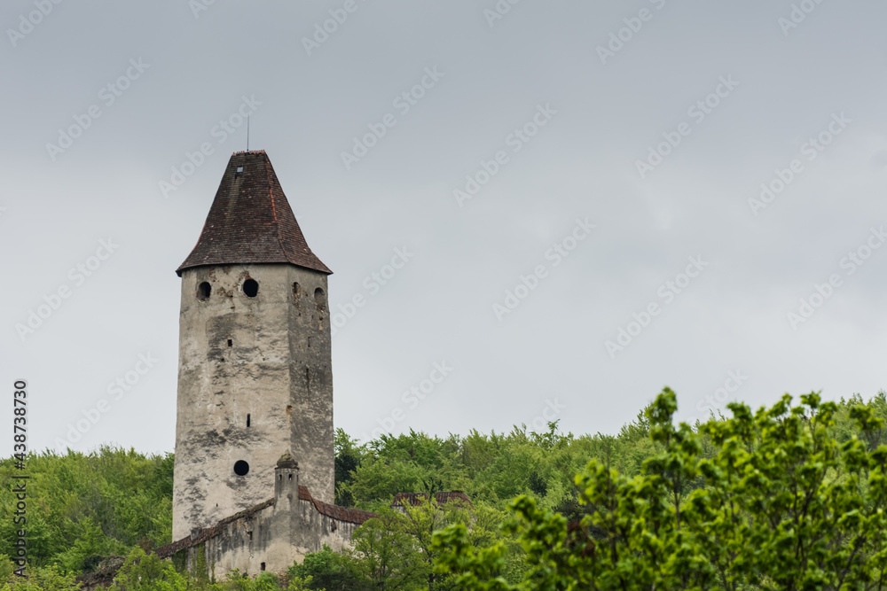tower with windows and a roof on a green hill