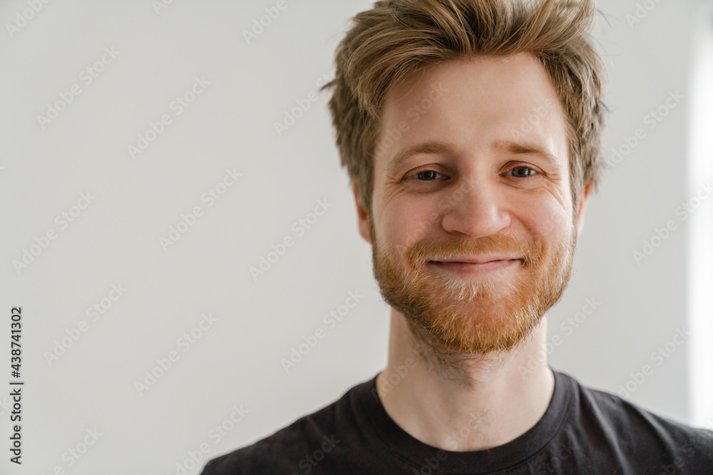White ginger man with beard smiling and looking at camera