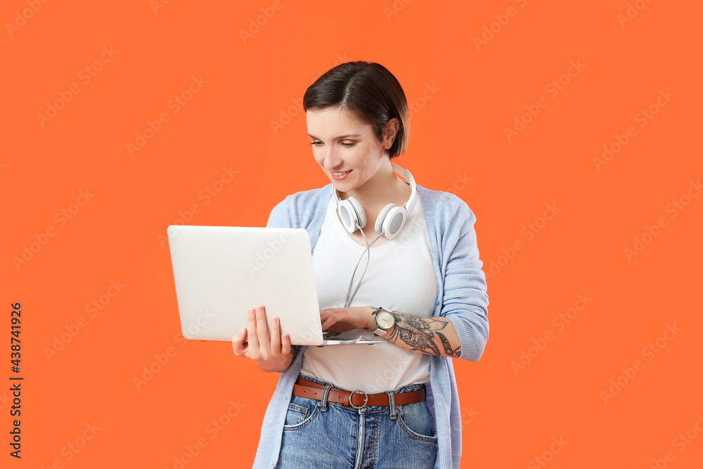 Female programmer using laptop on color background Female programmer using laptop on color background