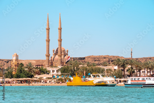 anorama of Old Market with the Al Sahaba Mosque in Sharm El Sheikh. Exotic cityscape with modern Muslim temple in Arabic architectural style. Blue sea in the foreground. View from the water photo