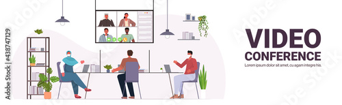 businesspeople in protective masks chatting with colleagues during video call coronavirus pandemic
