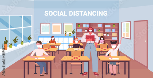 teacher and pupils in protective masks keeping distance to prevent coronavirus pandemic social distancing