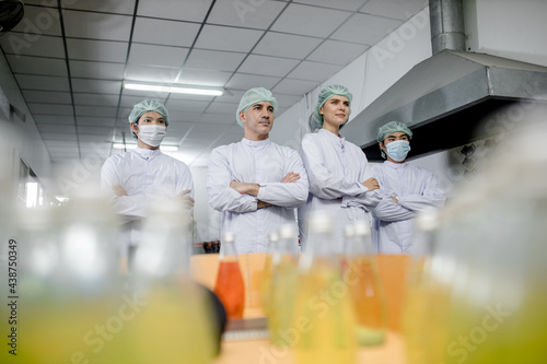 Groub workers in production line at drinks production factory background