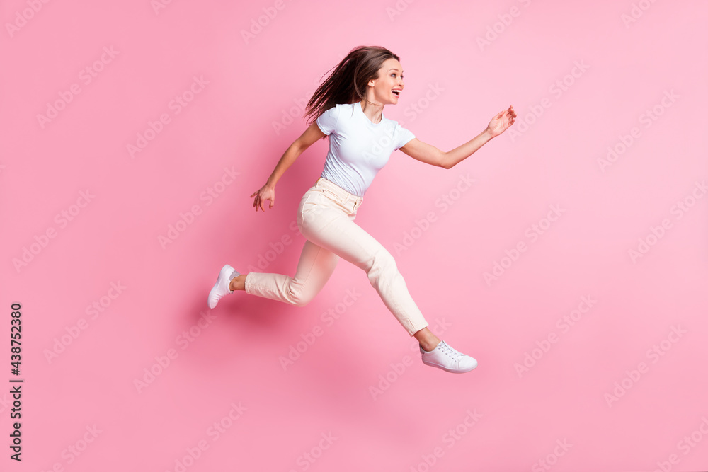 Full size profile photo of optimistic nice brunette hair lady jump wear t-shirt pants isolated on pink background