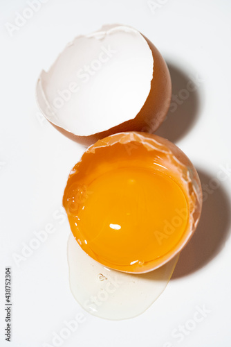 broken chicken egg on white background, vertical