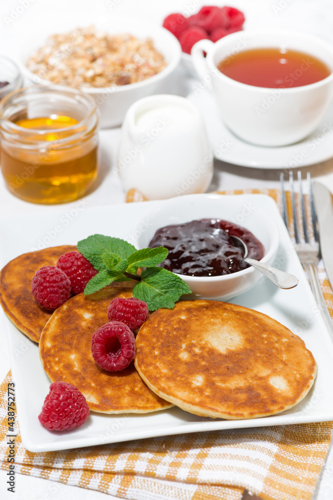 delicious pancakes with raspberries and jam for breakfast, vertical delicious pancakes with raspberries and jam for breakfast, vertical