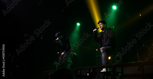 Singer holding a microphone stand and performing on stage. Rock concert show set up. © metha275