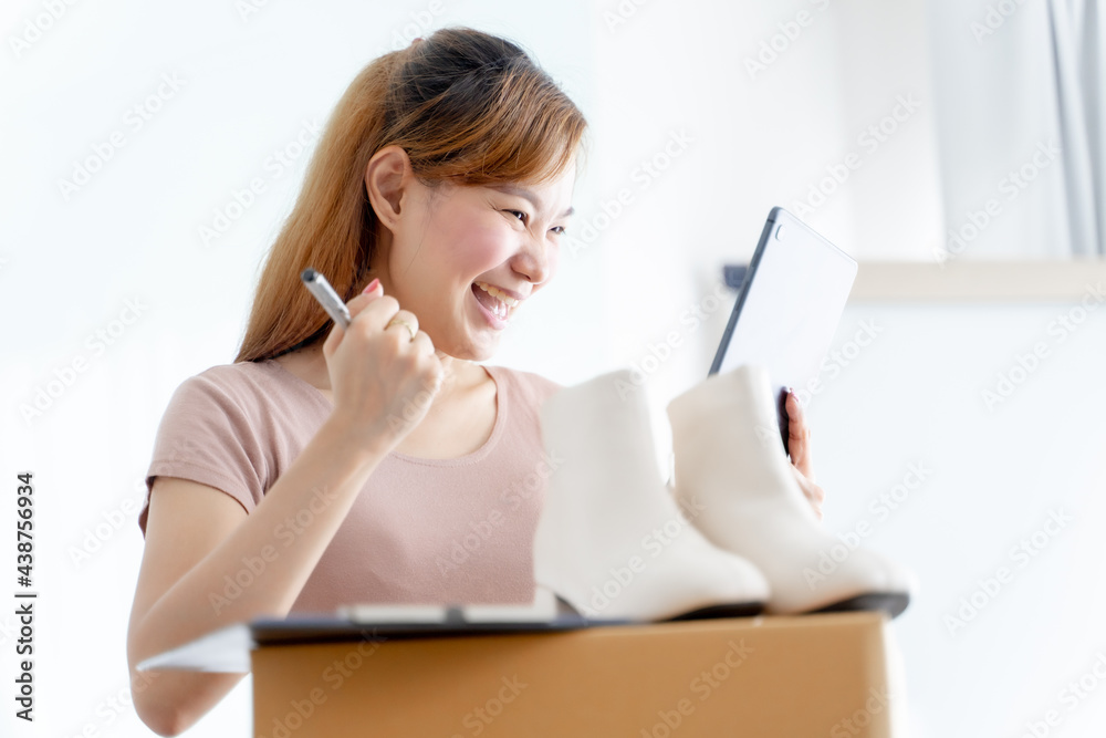 Asian young start up small business owner packing shoes in the box at workplace. Online selling, woman seller prepare product for packaging process at home, internet marketing, e-commerce concept Asian young start up small business owner packing shoes in the box at workplace. Online selling, woman seller prepare product for packaging process at home, internet marketing, e-commerce concept