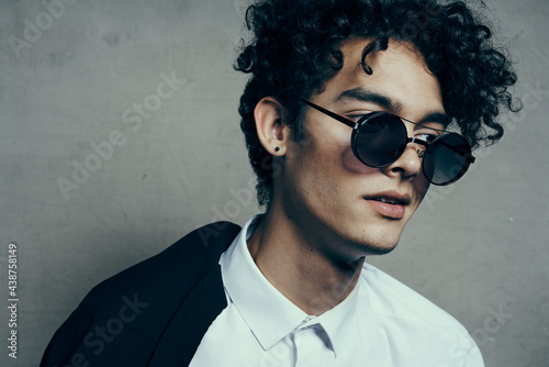 portrait of a Happy curly-haired guy in a classic suit and glasses