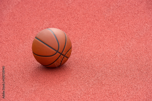 Orange basketball on brown court of gymnasium sport floor. Street basketball concept