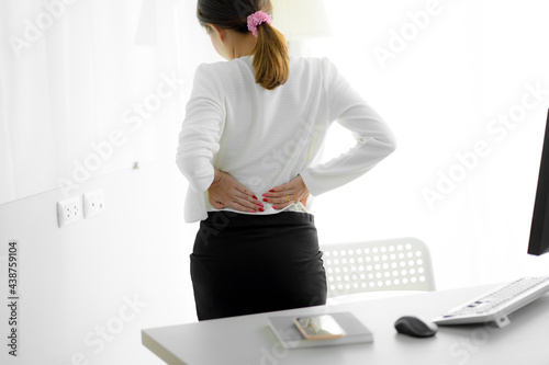 Asian woman with back pain in office