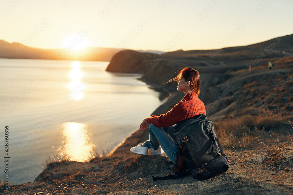 pretty woman tourist with backpack admiring the landscape sunset vacation