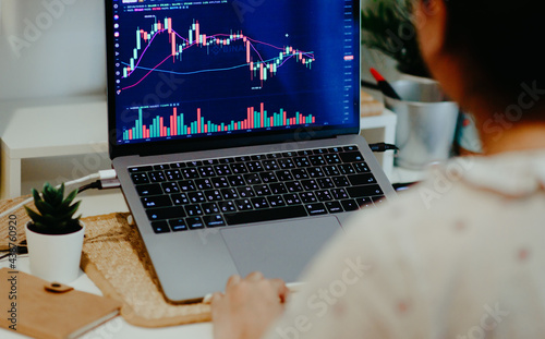 woman working in stock market using laptop Analyzing stock market trading data