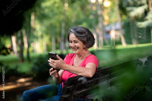 Senior woman using mobile phone in park.