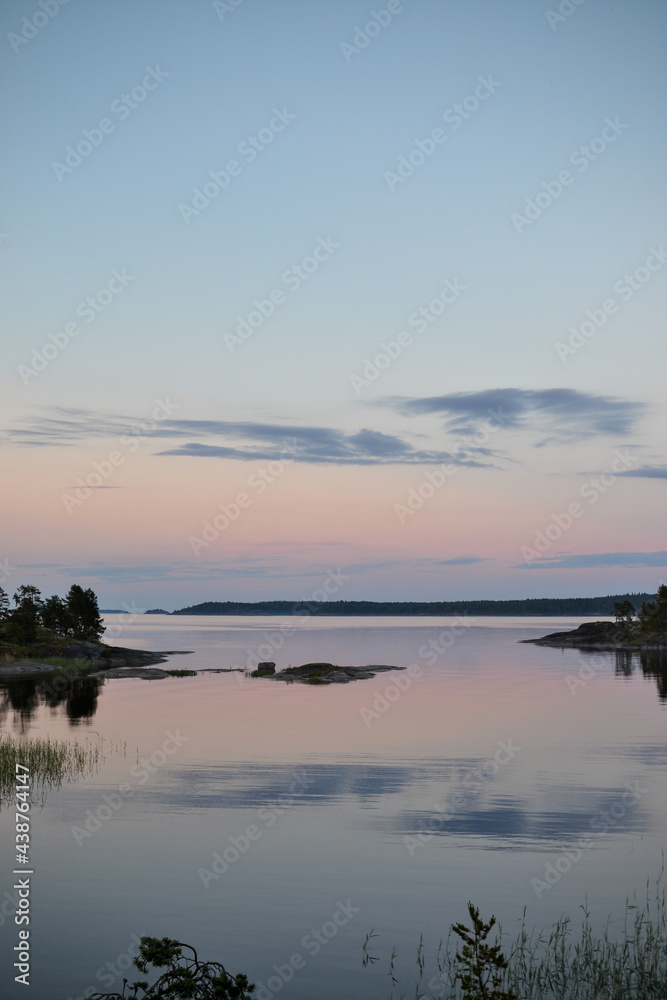 Fototapeta premium Evening nature at sunset, sunset lake view from the island, green grass and quiet lake, wilderness recreation and tourism, solitude, natural beauty for relaxation and enjoyment, island vacations and