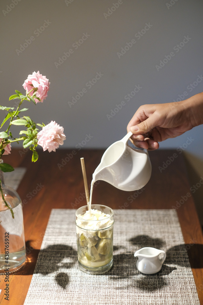 Coffee affogato with vanilla ice cream and espresso. Female hand pouring coffee in the glass with icecream	