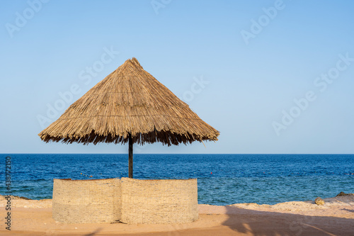 Luxury sand beach with beach chairs and straw umbrellas in tropical resort in Red Sea coast in Egypt  Africa
