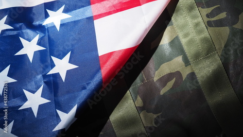 American flag and Military hat or bag. Top view angle. Soldier hat or helmet with national american flag on black background. Represent military concept by camouflage object and USA nation flag.  photo