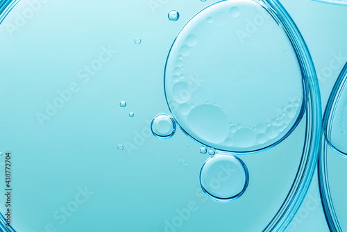 Beautiful macro photo of water droplets in oil with a blue background. Abstract art