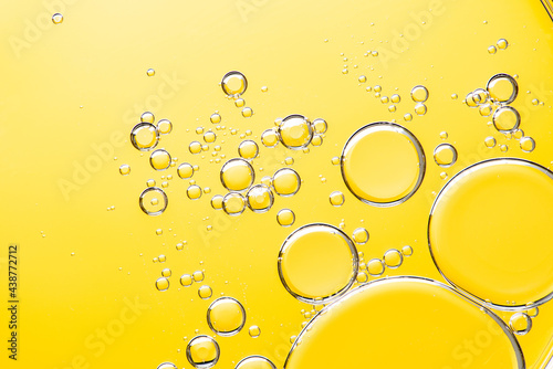 Beautiful macro photo of water droplets in oil with a yellow background. Abstract art