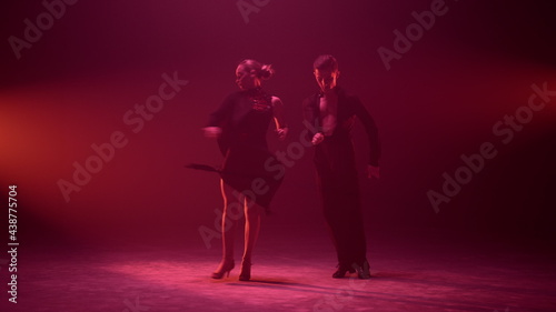 Dance couple bowing after performance on stage. Dancers greeting audience.