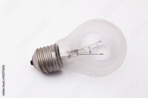 Vintage filament lamp light bulb laying on white table