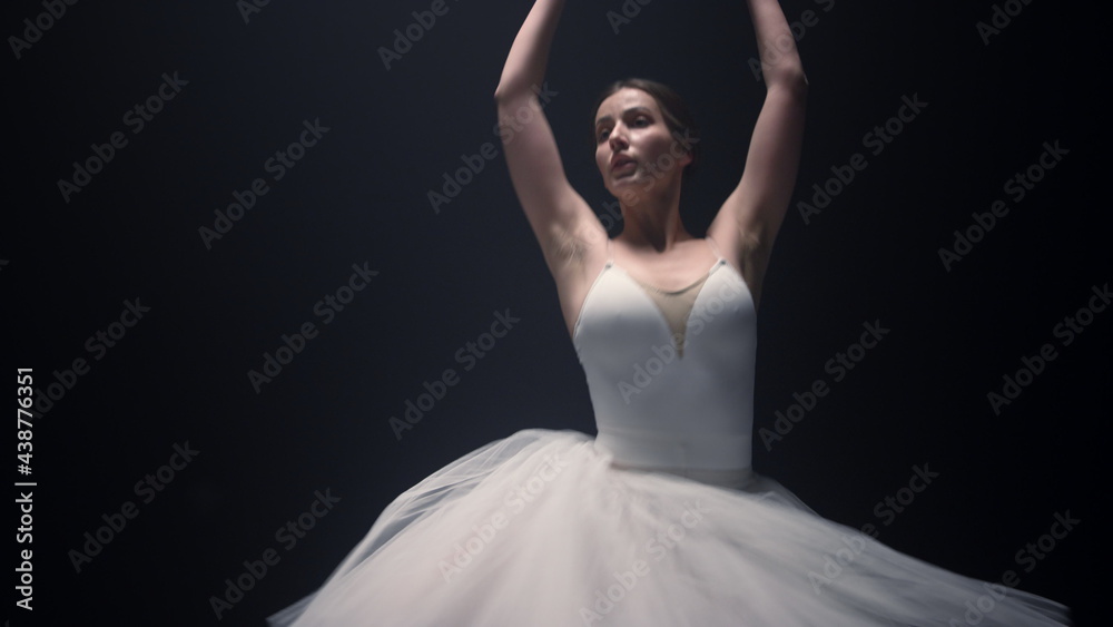 Fototapeta premium Beautiful ballet dancer spinning around in tutu skirt. Ballerina dancing stage.