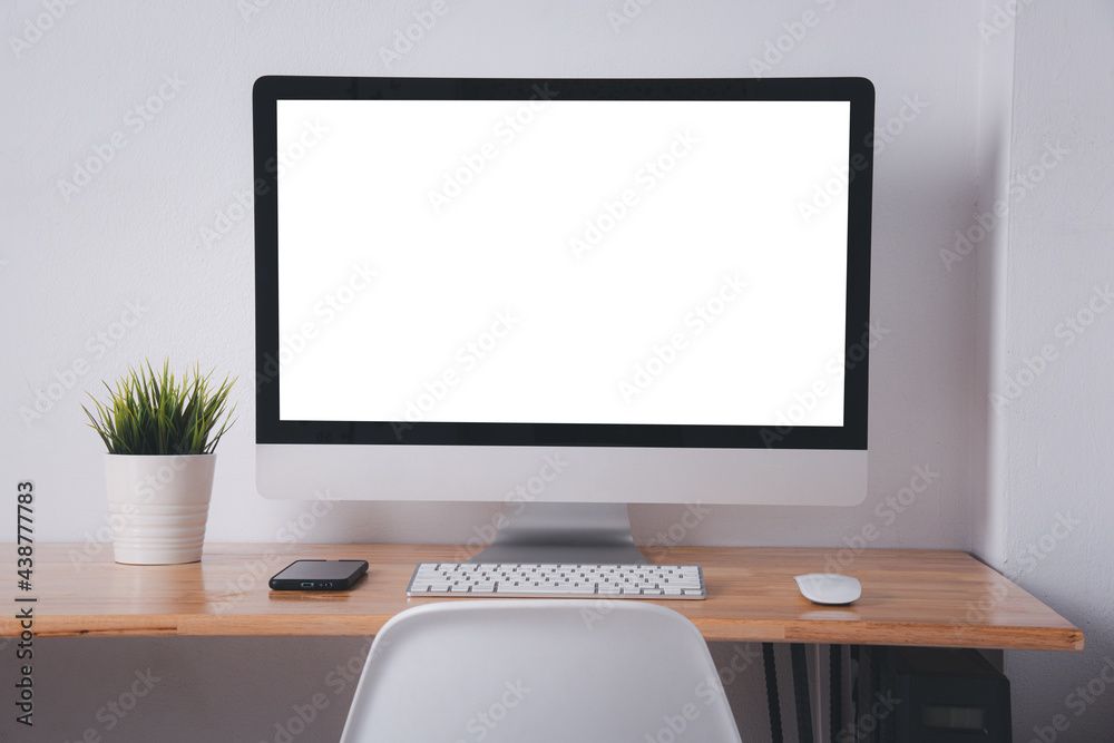 Computer monitor with white blank screen on the business desk with wireless mouse, keyboard at home office over white wall background, Photo of equipment contemporary workspace Computer monitor with white blank screen on the business desk with wireless mouse, keyboard at home office over white wall background, Photo of equipment contemporary workspace