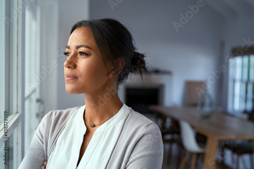 Fototapeta Thoughtful black woman looking outside window